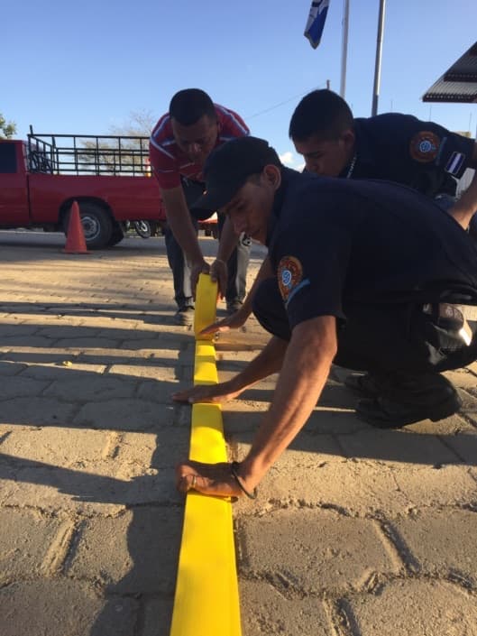 Condega firefighters practicing rolling a fire hose outside their station